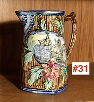 Front angled view showing ship relief and floral decorations on antique majolica pitcher