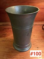 Front view of antique pewter vase showing the flared spout and body with two decorative horizontal rings.