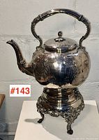 Full view of tilting teapot on ornate stand