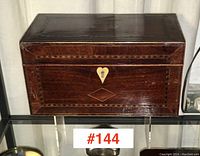 Front view of mahogany box showing inlaid stringing and brass escutcheon
