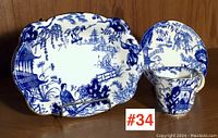 Full set showing the cup, saucer, and small dish with blue and white oriental design and gold edging.