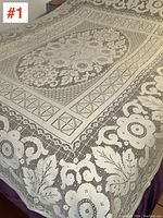 Overall view of the lace tablecloth showing floral and geometric lace patterns along the edges and center.