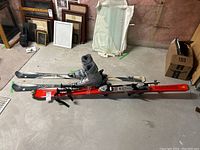 Photo showing both sets of skis laid on the floor with boots attached on Rossignol skis