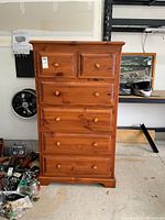 Front view of pine highboy dresser showing six drawers and round wood knobs.