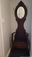 Full front view of hall tree showing mirror, hooks, and seat storage
