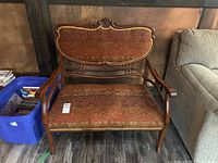 Front view of two-seat settee showing patterned upholstery and wooden frame with carved detailing.
