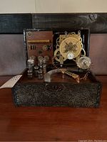 Front view of steampunk decorative box showing faux clock with visible gears, glass tubes, and coiled wires inside.
