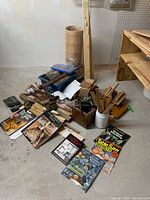 Lot contents including books, clamps, chisels, shims, and cribbage board template arranged on the floor.