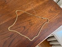 Full view of the necklace laid flat on a wood surface