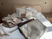 Full view of bed with all bedding components arranged on it including pillows, sheets, bedspread, and comforter
