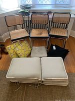 Three wicker chairs and assorted cushions front view