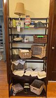 Full view of shelf containing all items for sale including lamp, vases, bookends, baskets and hankies