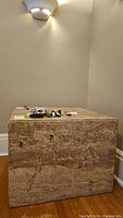 Front view of the travertine cube side table with polished top and natural stone pattern