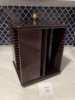 Full view of the dark wooden CD stand with vertical CD slots on two sides and center divider.