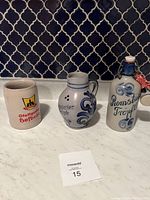 Three vintage German salt glazed pottery pieces including a beer stein and two handpainted jugs.