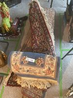 Rolled large rug with small decorative rug placed on top, showing both items