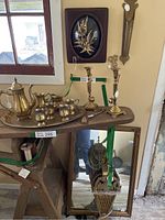 Brass tea service and candlesticks on table near window showing all items