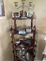 Wooden shelf showing candelabra and various coasters and small containers on tiers