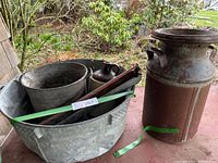 Photo showing full lot from wide angle: galvanized wash tub, pail, ceramic jug, wooden feeder item, rusted milk can