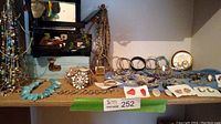 Full shelf view showing box, necklaces, bracelets and earrings arranged on stand