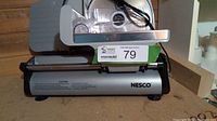 Side view of the Nesco electric food slicer showing the product body with label and power cord.