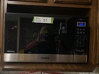 Front view of Panasonic microwave oven with reflective black and stainless steel finish, digital control panel displaying 9:51.