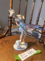 Full front three-quarter view of the lady figurine standing beside poodle on oval base