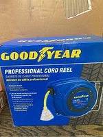 Blue Goodyear branded box showing product image and key features of the professional cord reel.