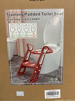 Front view of product packaging showing the padded toilet seat mounted on a toilet with the integrated step stool ladder in a reddish-brown color.