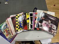 Top view of the complete collection of 17 vinyl albums laid out on a table, showing a variety of cover art styles and colors.