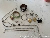 Overview photo showing assortment of costume jewelry items on white countertop surface