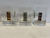 Front view of all three lucite blocks showing embedded film frames and engraved titles