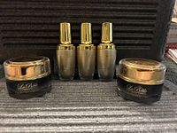 All five items in lot together - 3 Non-Surgical Dark Circle Removal Serum bottles and 2 Lava Bio Thermal Silk Cream jars
