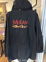 Rear view showing back side with large embroidered “Mulan” logo in red and gold