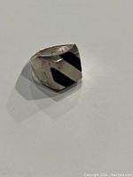 Ring view showing black onyx inlay with diagonal stripes on a square face, highlighting design and condition.