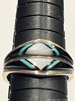 Front close-up of ring showing turquoise and lapis lazuli inlay pattern on polished sterling silver band on ring sizer.