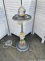 Full view of standing chrome and glass smoking stand showing base, central column, glass orb and power cord