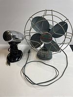 Photo showing front view of Electrohome fan beside Oster Atomic Air Dryer with cords visible