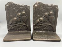 Front view of both bronze owl bookends with gothic castle background showing three owls on a branch.