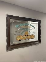 Front angled view of the vintage Imperial Oil Company advertising mirror mounted on a wall showing all painted text and logos, and the dark wood frame.