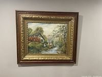 Full view of the framed oil painting on board showing the complete scene and ornate carved frame against a beige wall.