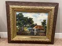 Full view of the framed oil on board painting depicting a watermill surrounded by trees and sky.