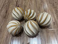 Top view of the five decorative spiral balls arranged on wood surface, showing their size and gold accented spirals.