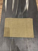 View of one rectangular woven placemat, showing overall size and texture.