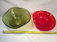 Pair of colorful glass display bowls placed next to a measuring tape showing size.