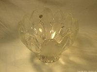Clear molded glass fruit bowl with petal-like faceted design, showing full bowl shape