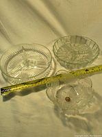 Overview of three glass serving dishes with measuring tape showing size.