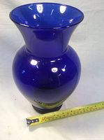 Front angled view showing cobalt blue glass vase with bulbous body and flared top