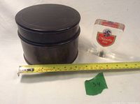 Photo shows round dark wooden jar next to O'Keefe Ale draft tap handle with tape measure indicating jar size.