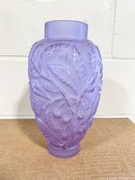 Front view of the purple Alexandrite glass vase showing detailed relief leaf and fruit patterning.